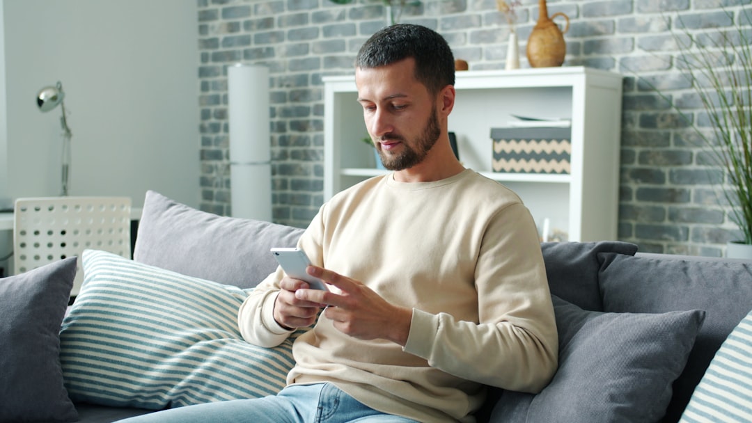 Man in his 40s texting on his phone at home