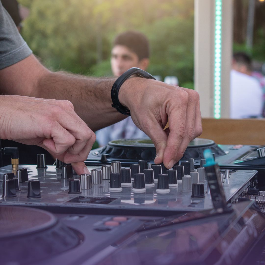 Professional DJ hands mixing music on DJ controller at private party event