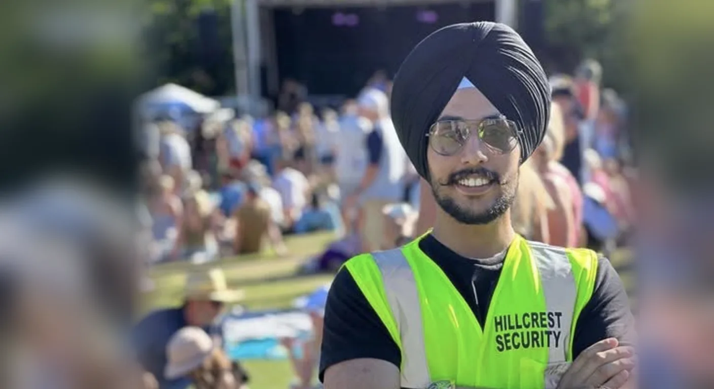 Hillcrest Security guard in a high-visibility vest standing with arms crossed in front of a festival crowd