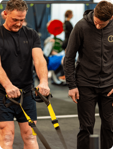 An OC coach guiding a member during a session