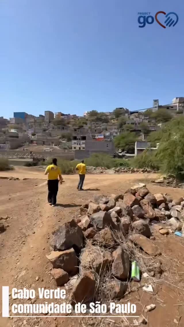 The dry hills of Santiago island, Cape Verde, with the team walking to a community