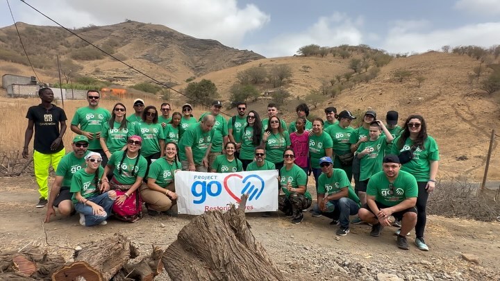 The 2024 Project Go team in green shirts with the Project Go banner in the hills of Santiago