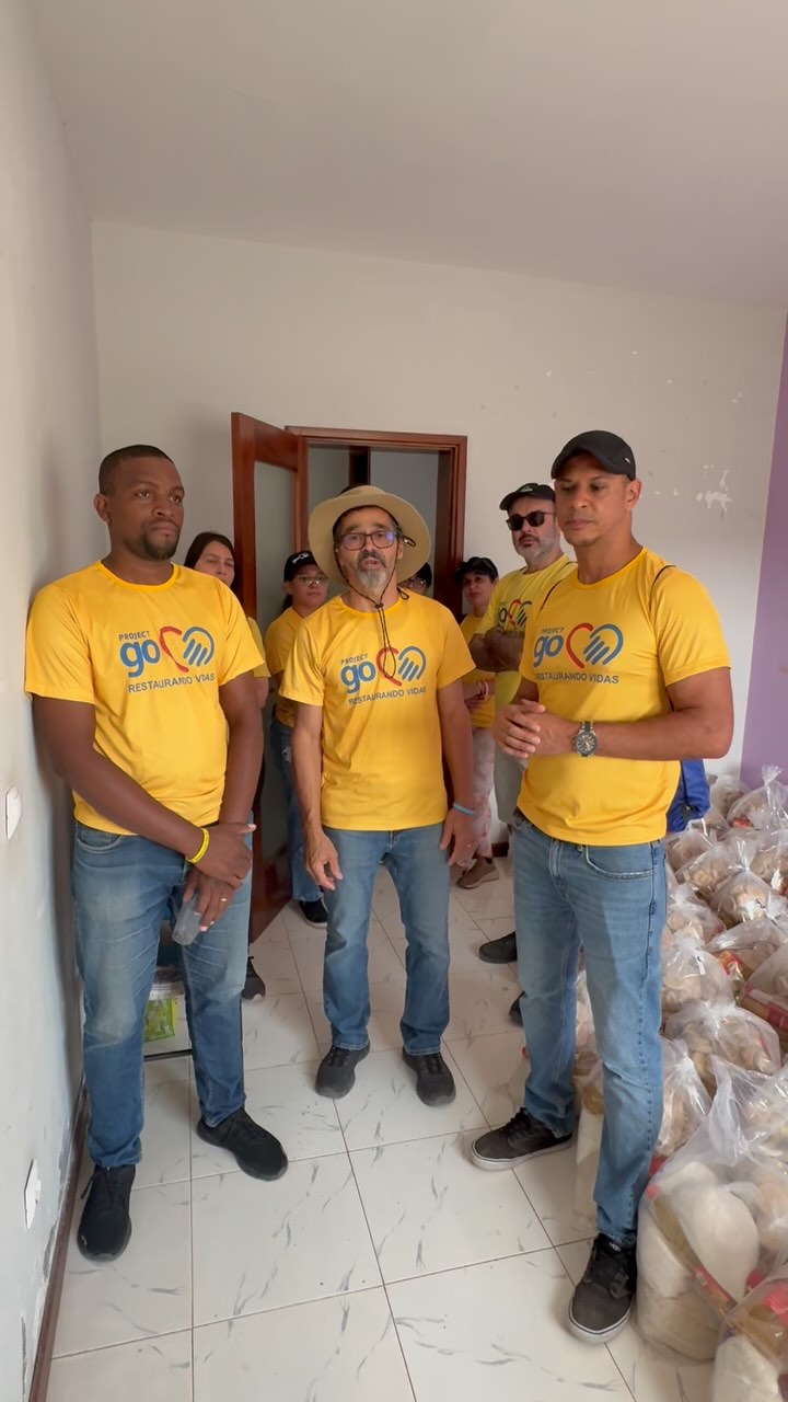 Project Go team in yellow shirts standing beside packed food baskets in 2025