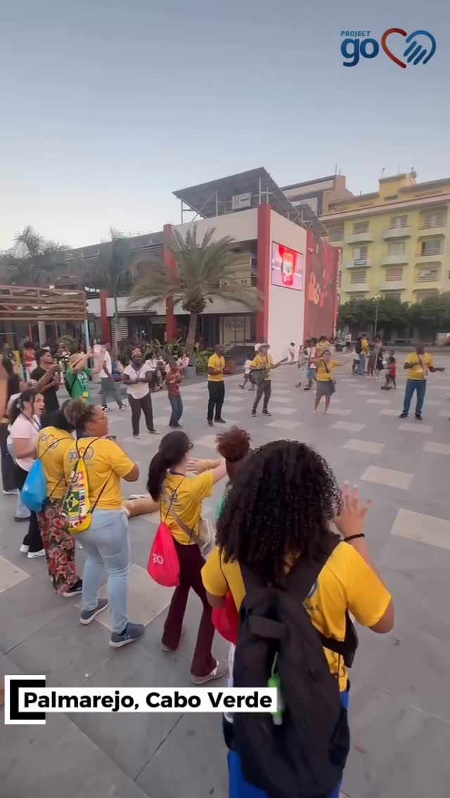 Project Go team in yellow shirts walking a street in Praia, Cape Verde