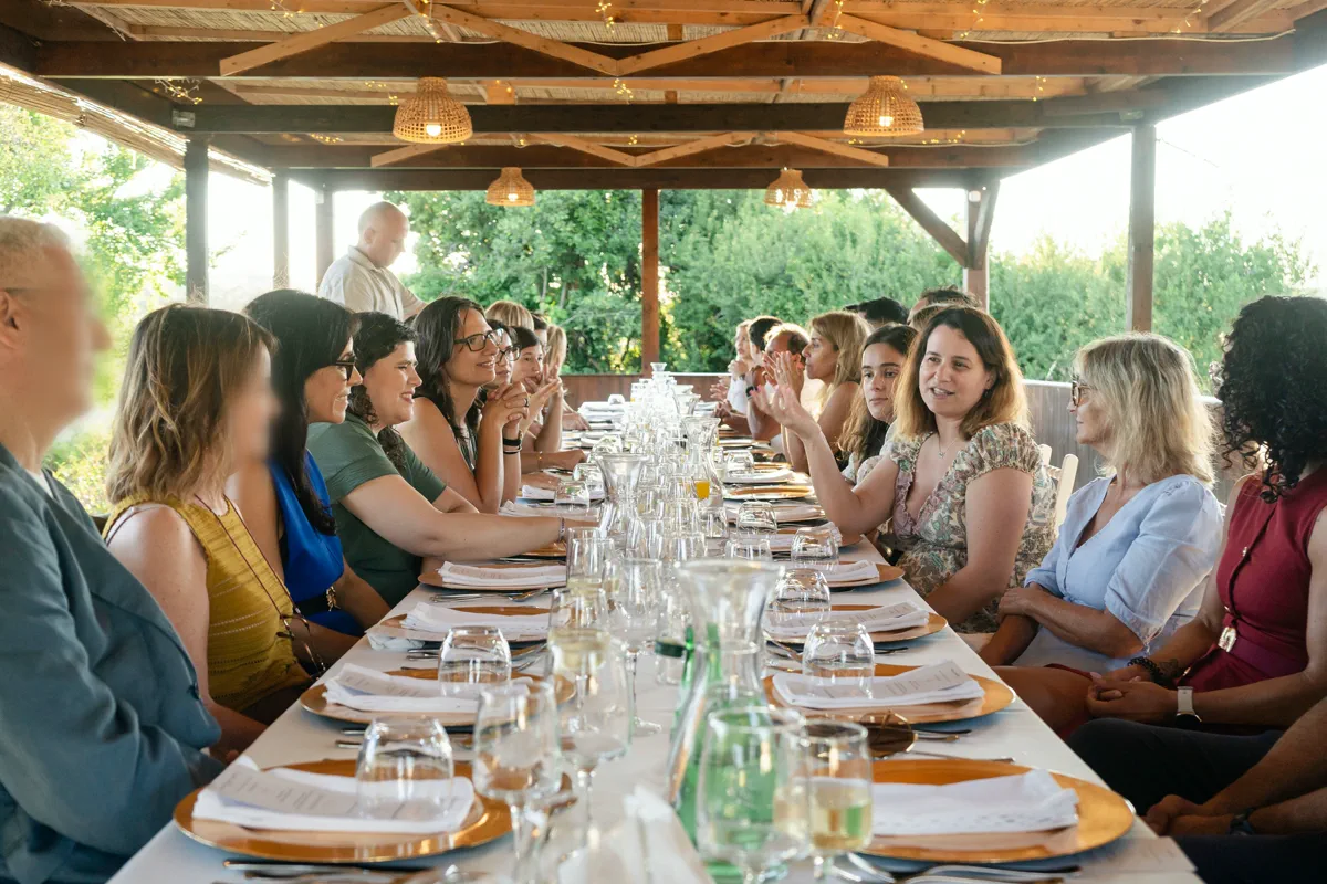 A mesa comprida sob a pérgula, com os participantes já sentados