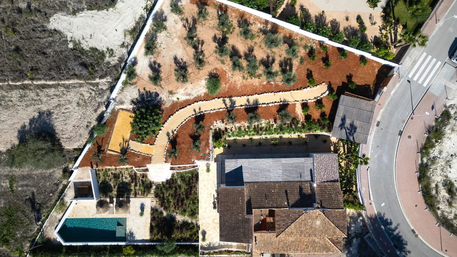 Vista aérea de la vivienda Las Brisas en Jávea: parcela escalonada en plataformas con piscina y jardín