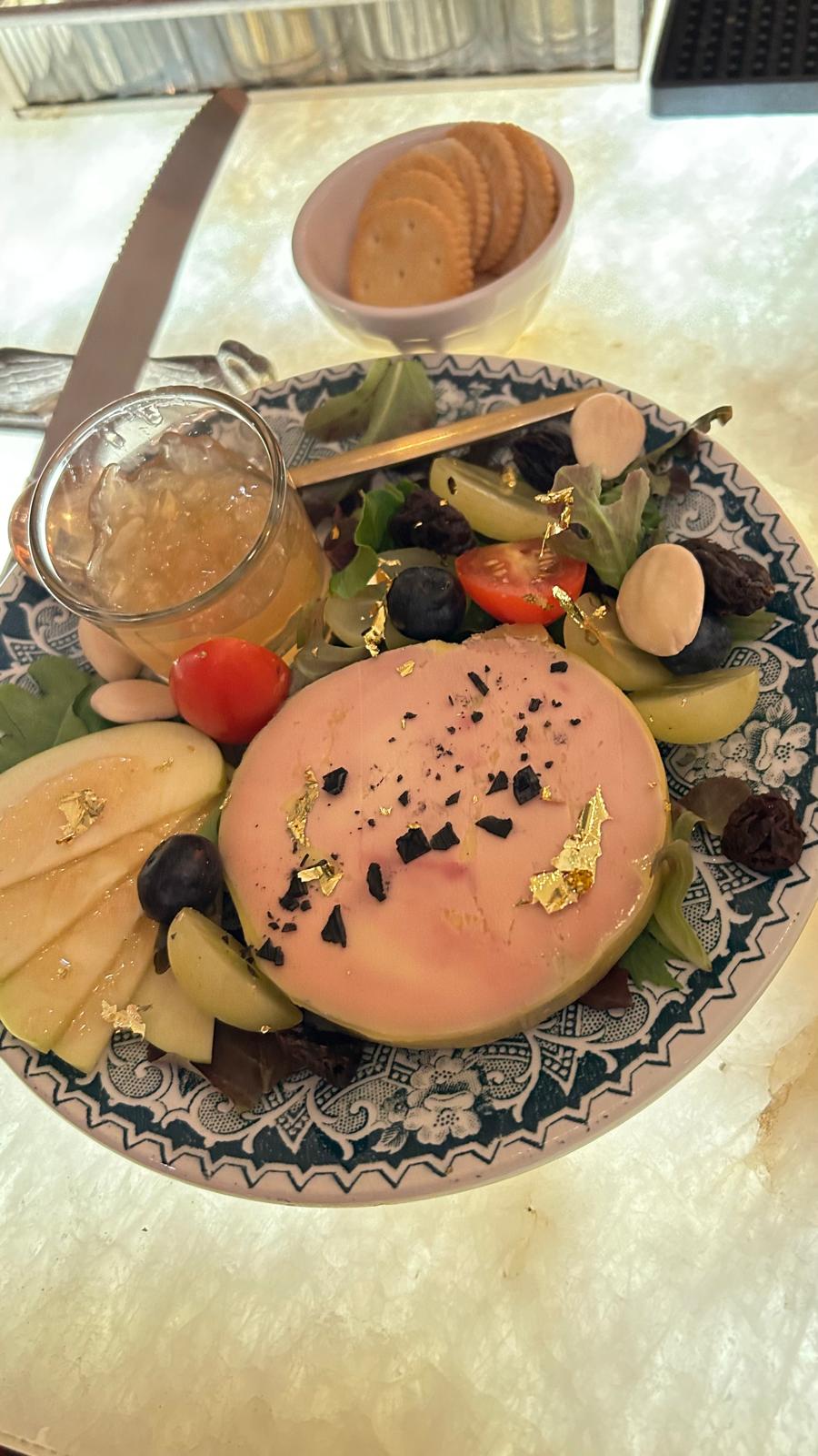 A plate of pâté, cheeses, fruit and gold leaf — the harvest table