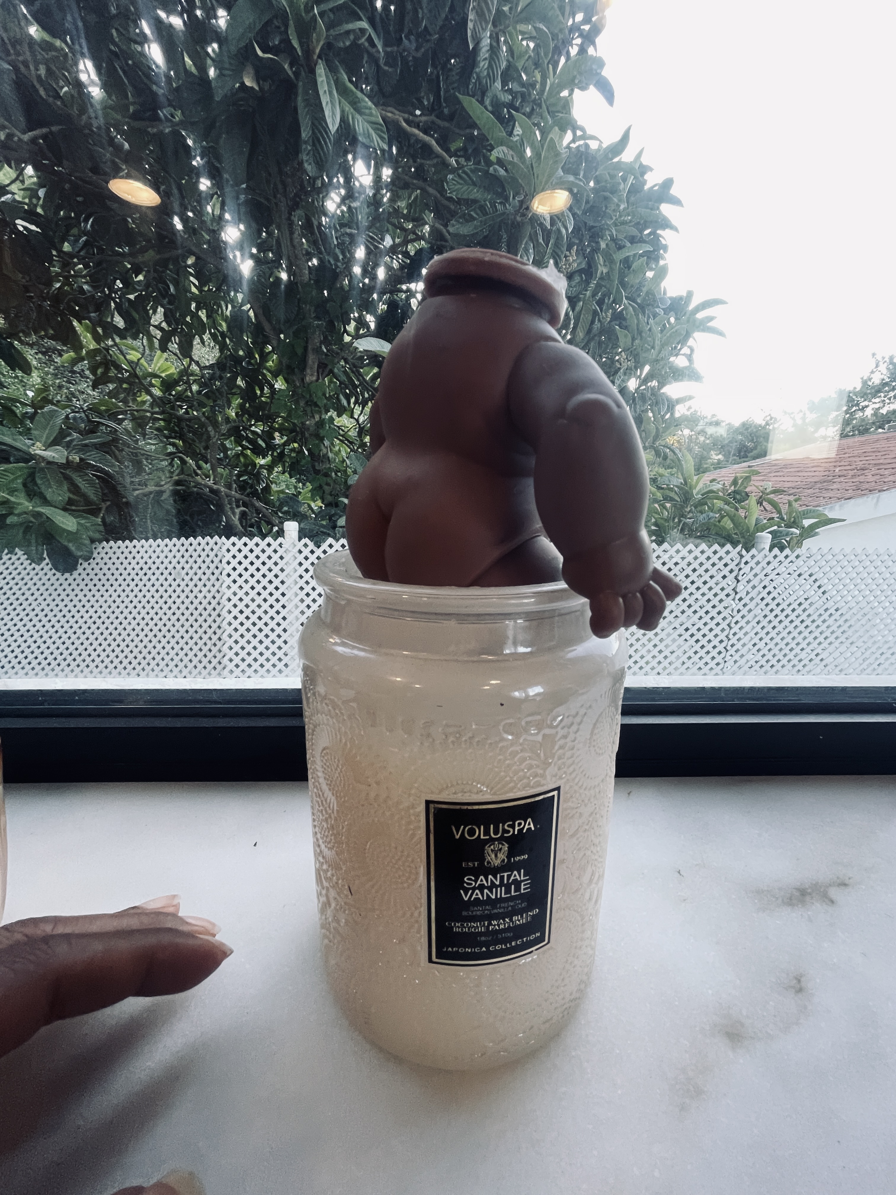 A headless baby doll set into a candle — a child's love offering
