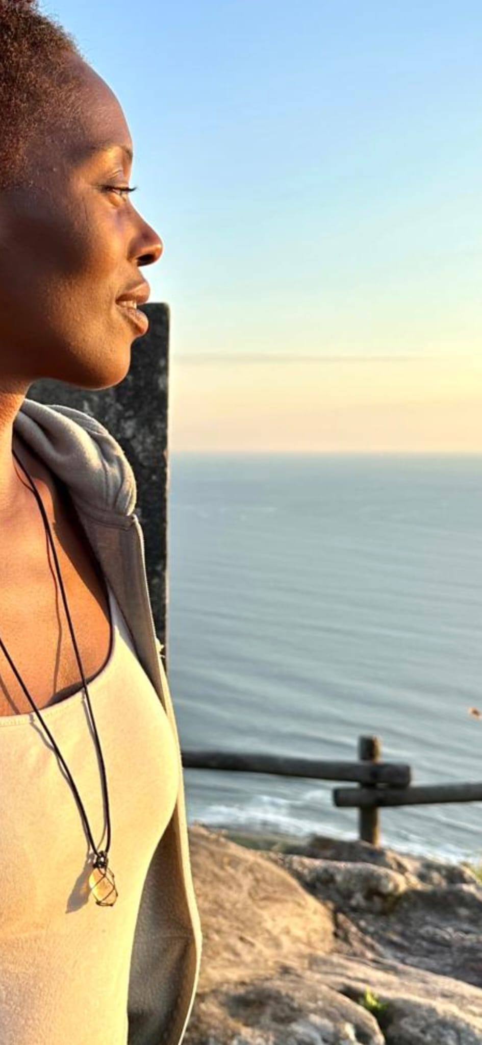 A woman at the cliff's edge looking out to sea