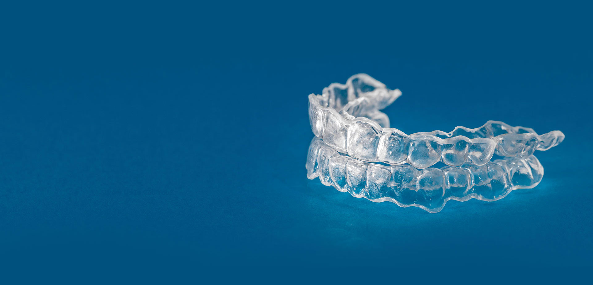 Patient placing a clear Invisalign aligner