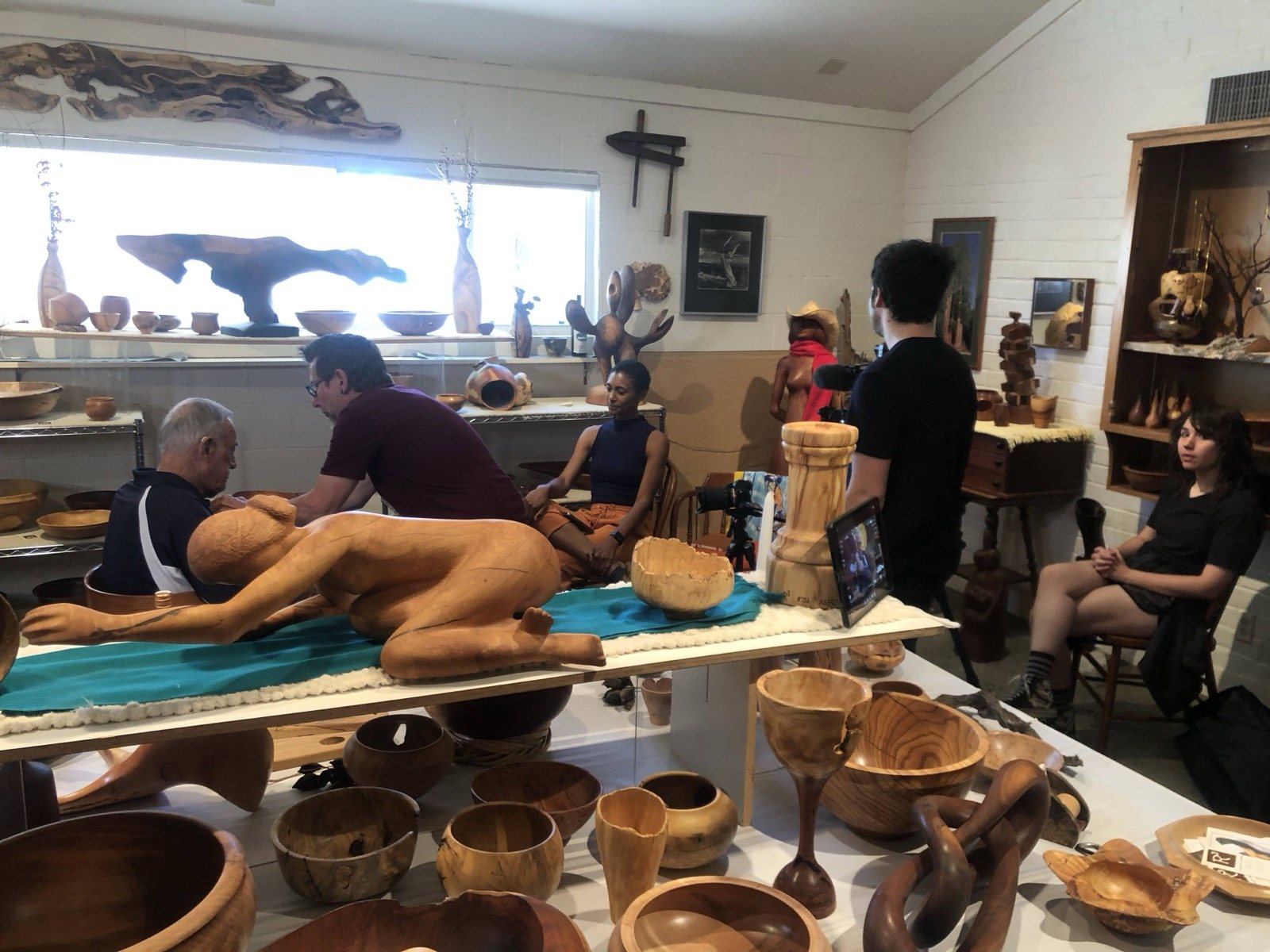 Wide view of artwork and visitors in the studio