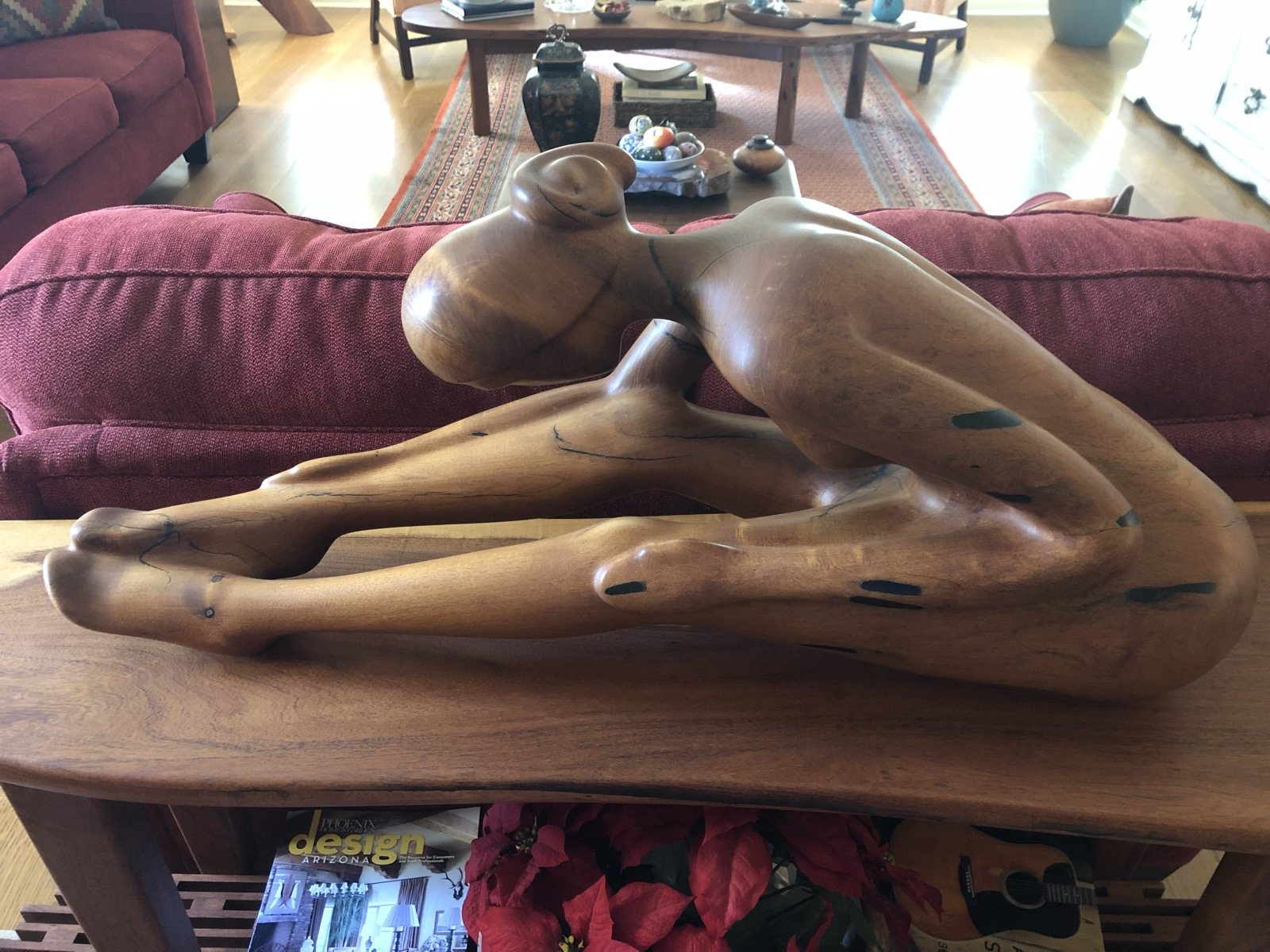 Carved reclining human figure in warm polished wood