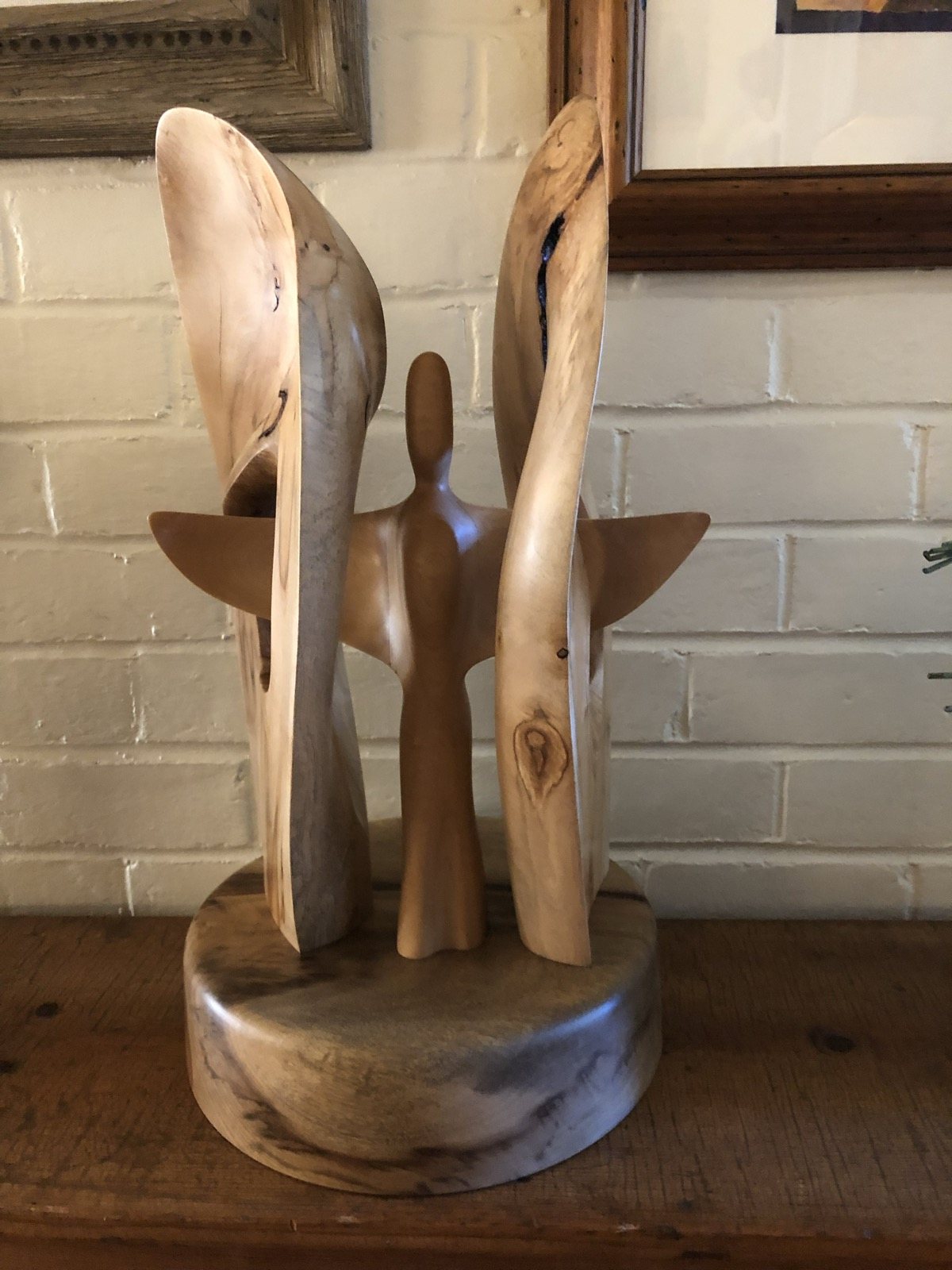 Tall organic wooden forms mounted on a round base