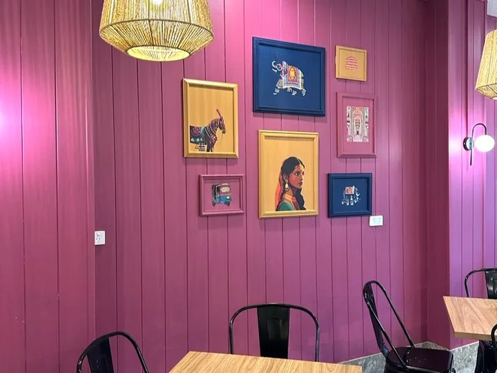 Pink feature wall with framed artwork in the renovated Naan Sense dining room