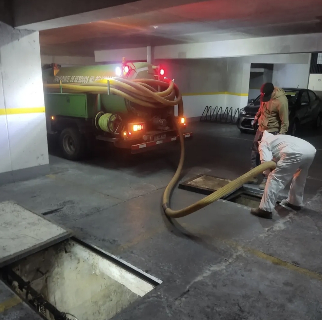 Camión limpia fosas de BYM trabajando en el estacionamiento de un edificio