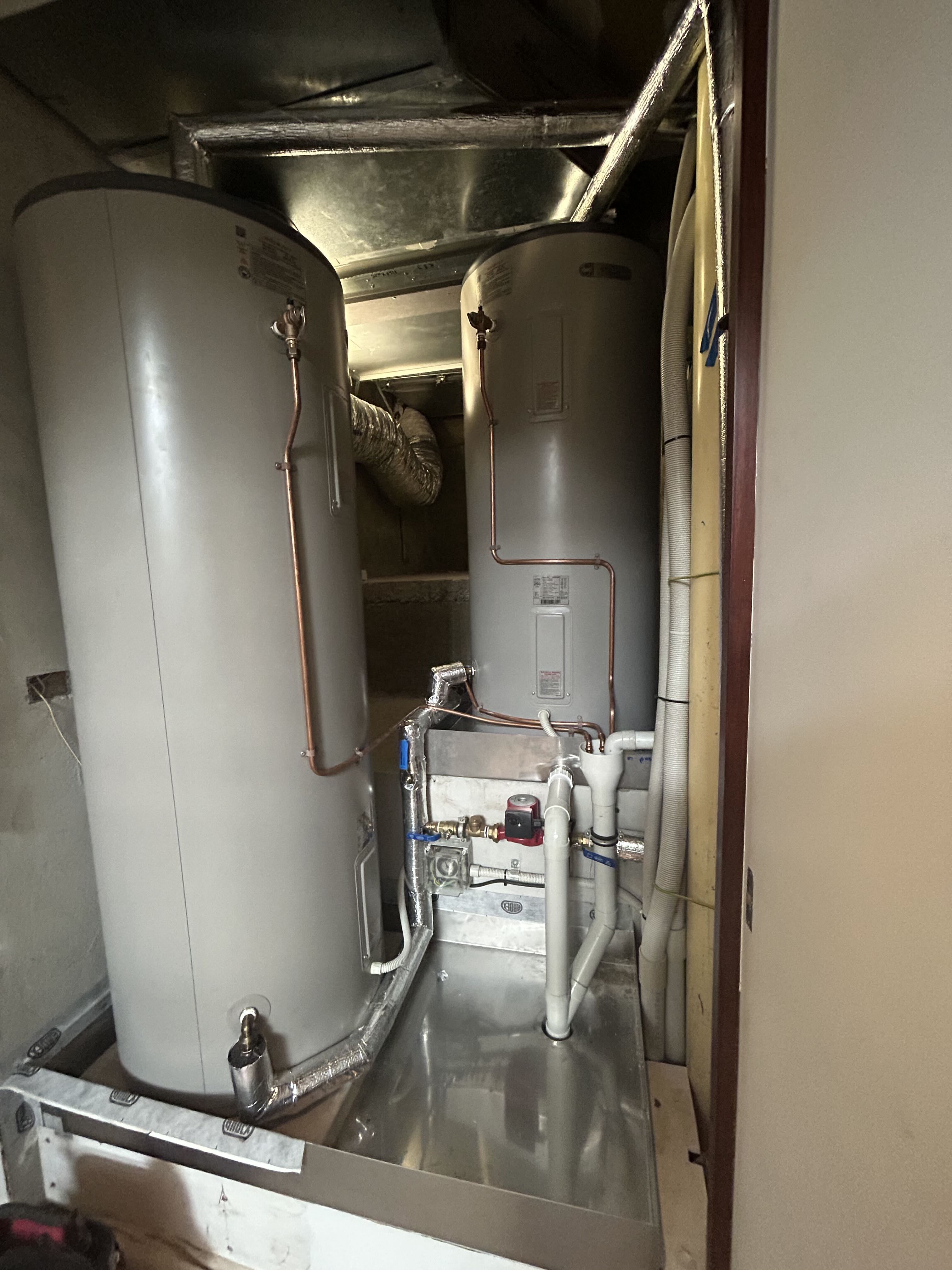 Twin hot water storage tanks installed in cupboard