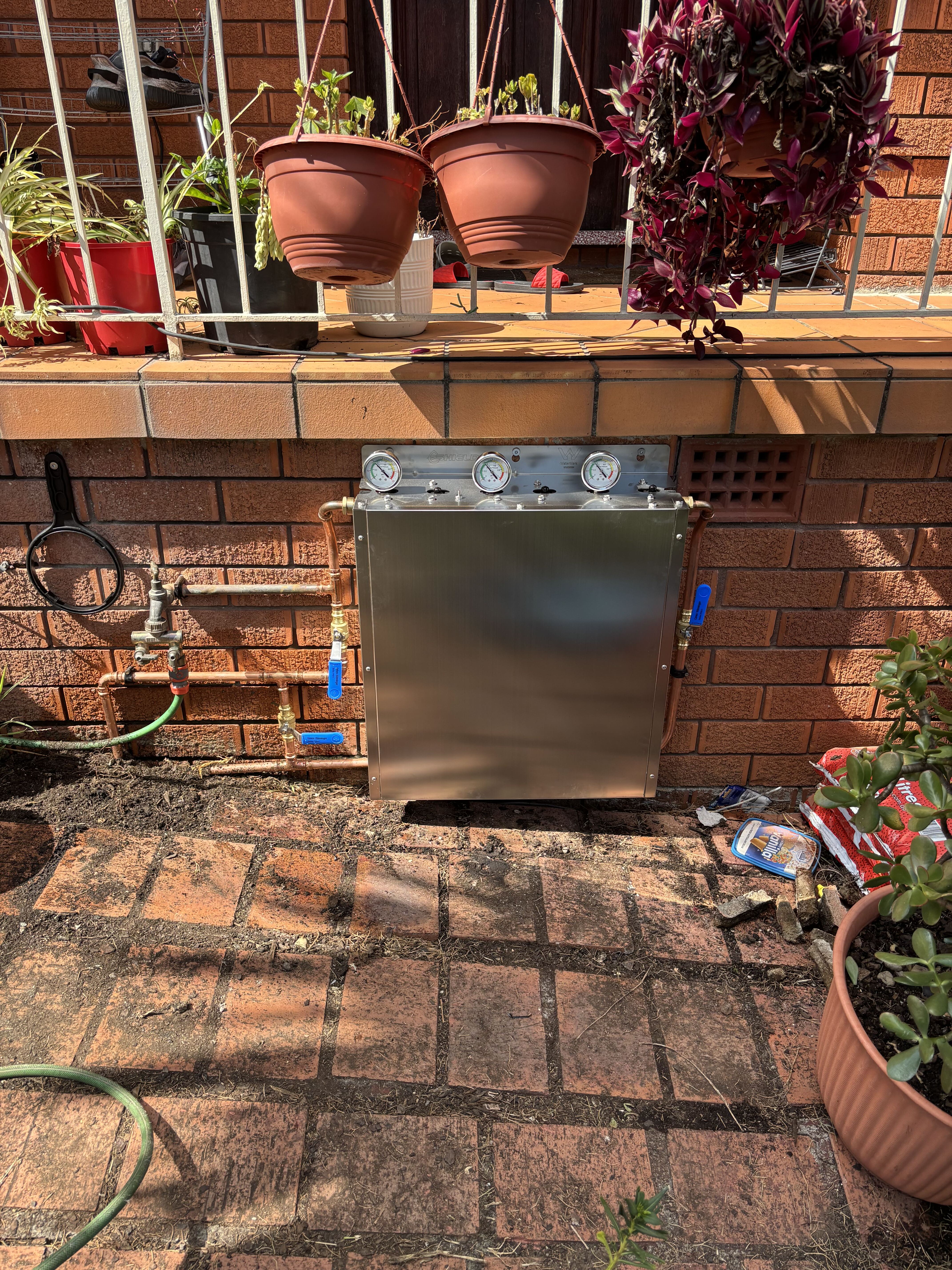 Water filtration system with pressure gauges under brick ledge