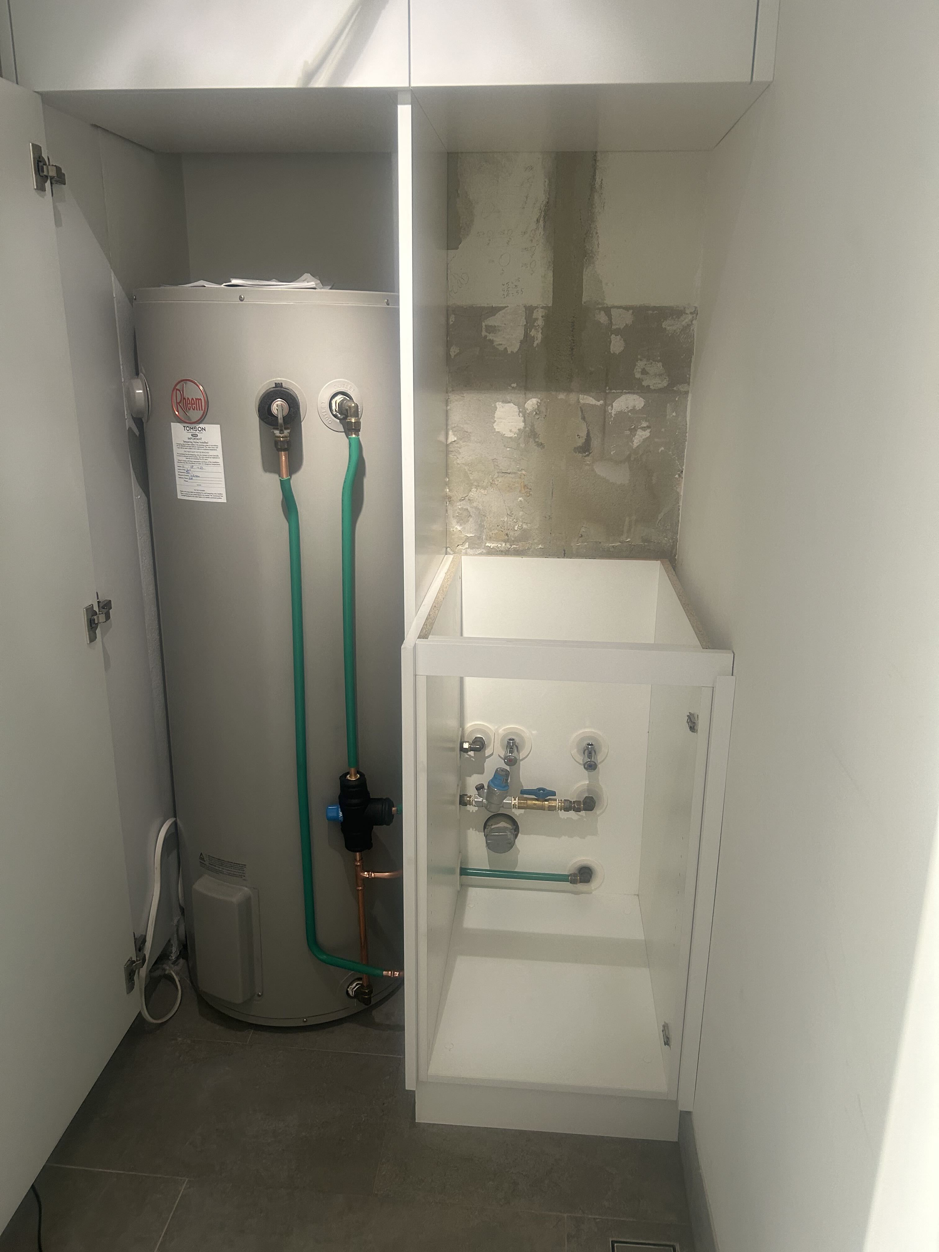 Electric storage hot water unit in laundry cupboard
