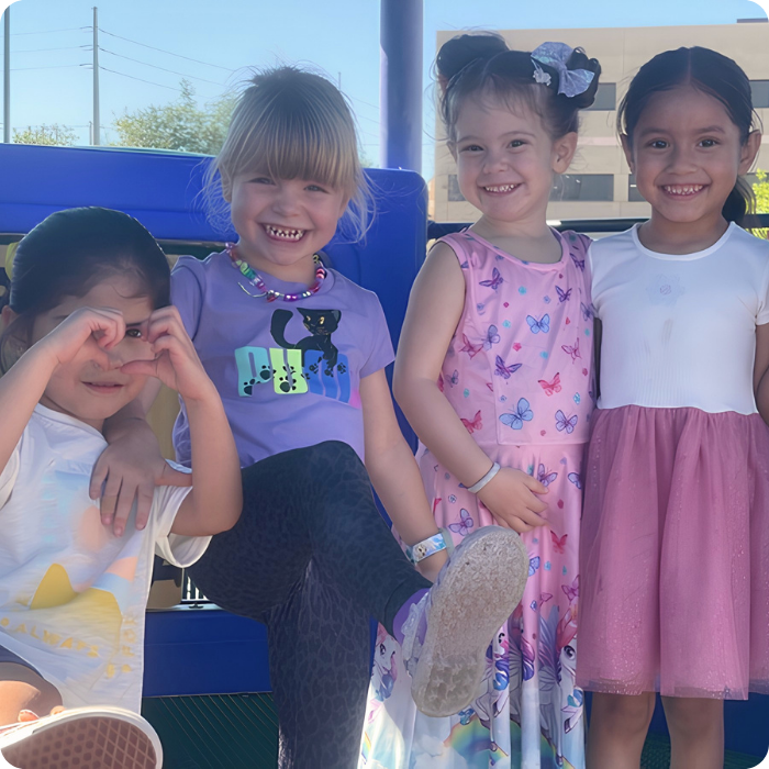 children smiling playing outside at daycare in New Mexico