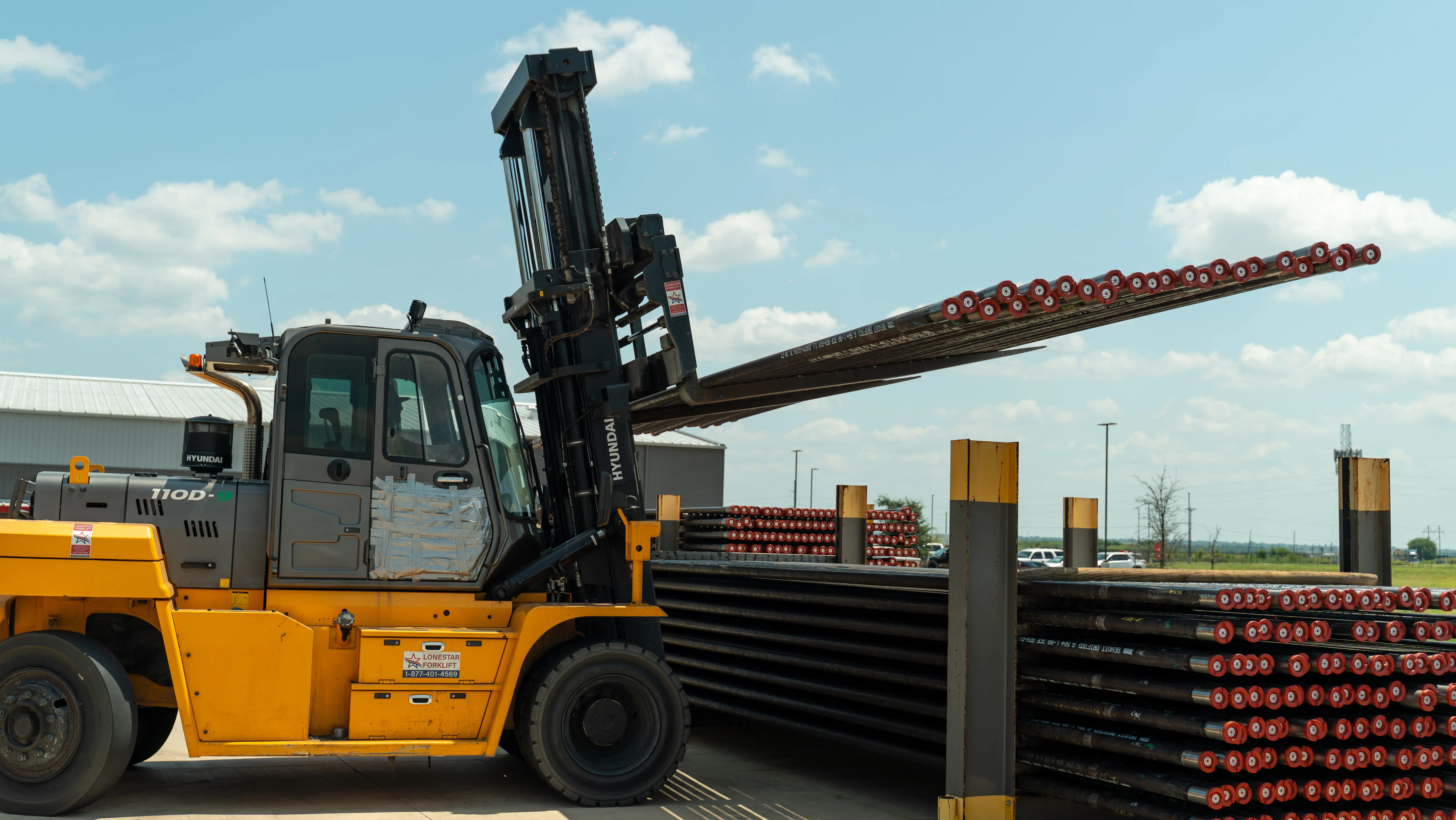 Heavy forklift lifting drill pipe — industrial operations photography Houston