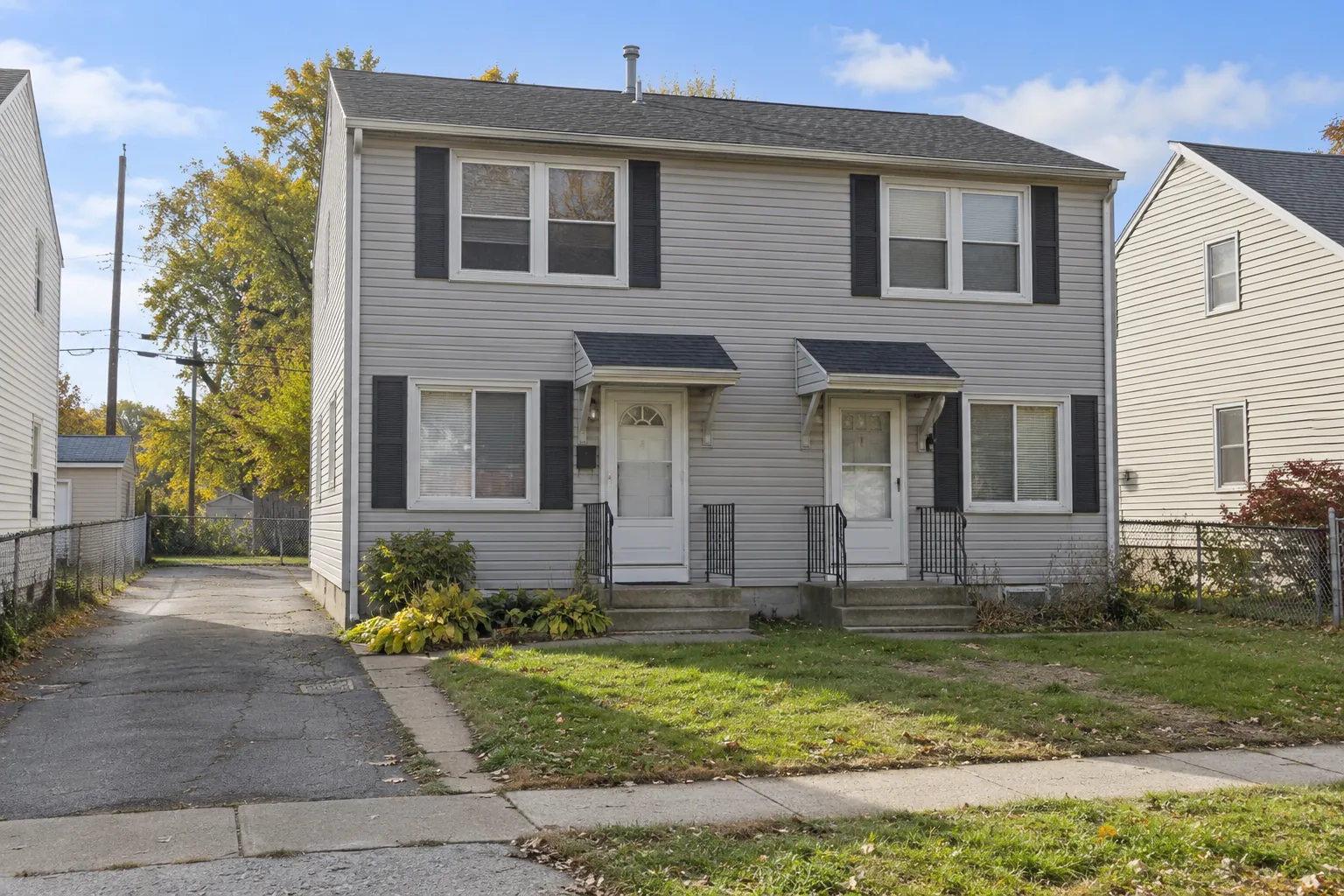 A side-by-side duplex with two front doors and a shared driveway