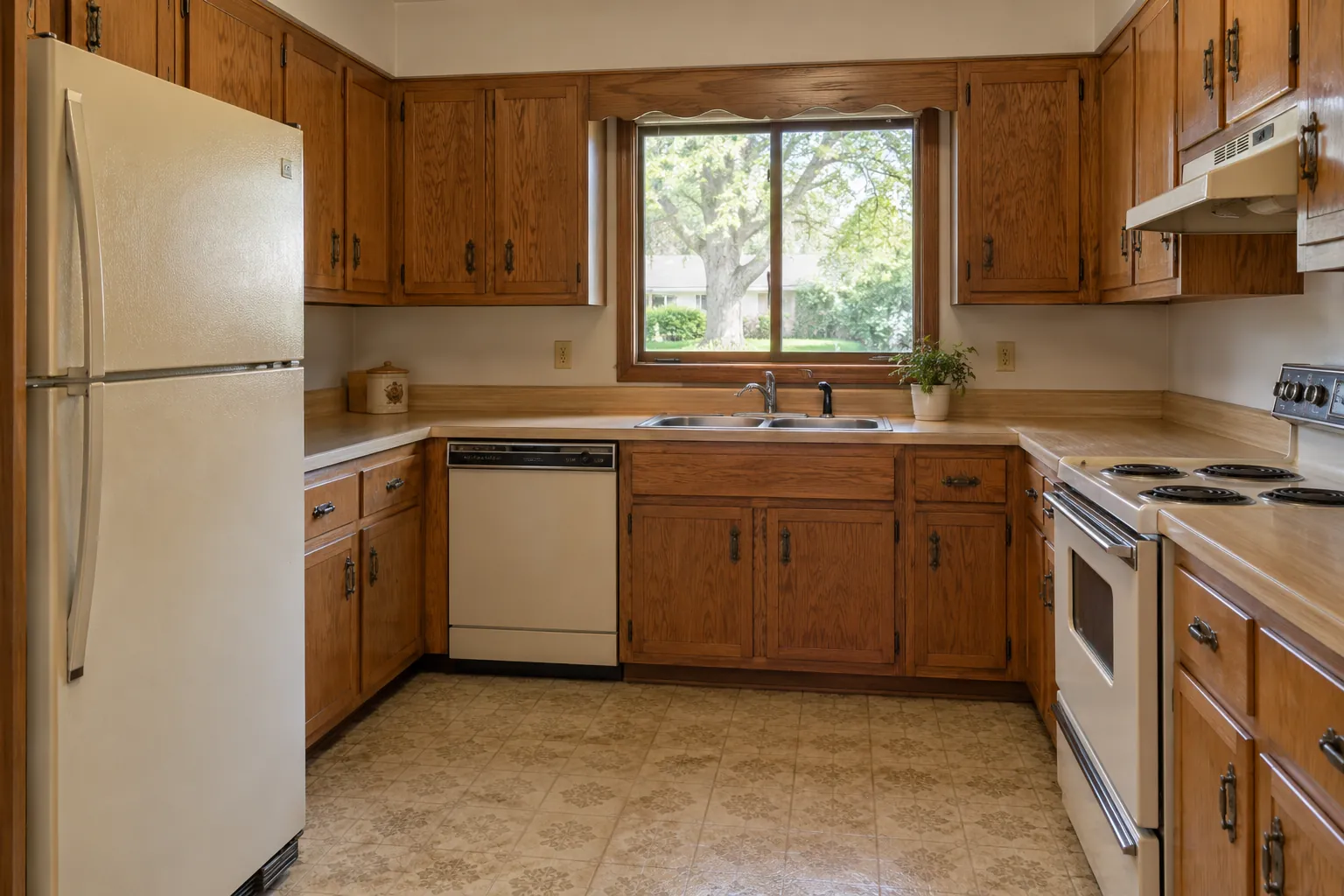 A dated kitchen with oak cabinets, laminate counters and almond appliances