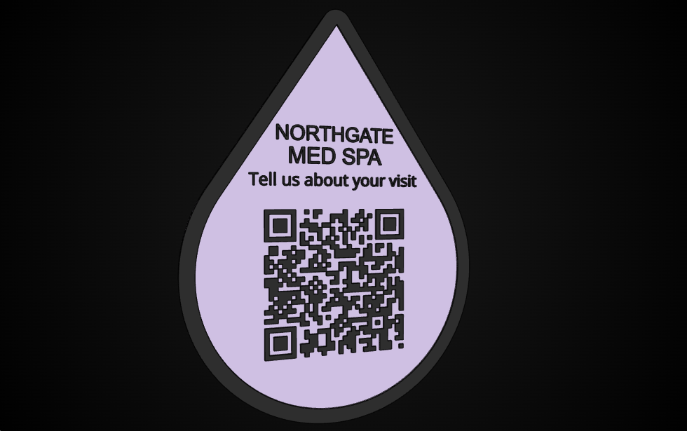 3D printed lavender teardrop-shaped review plaque for Northgate Med Spa, with raised charcoal lettering reading Tell us about your visit above a large QR code