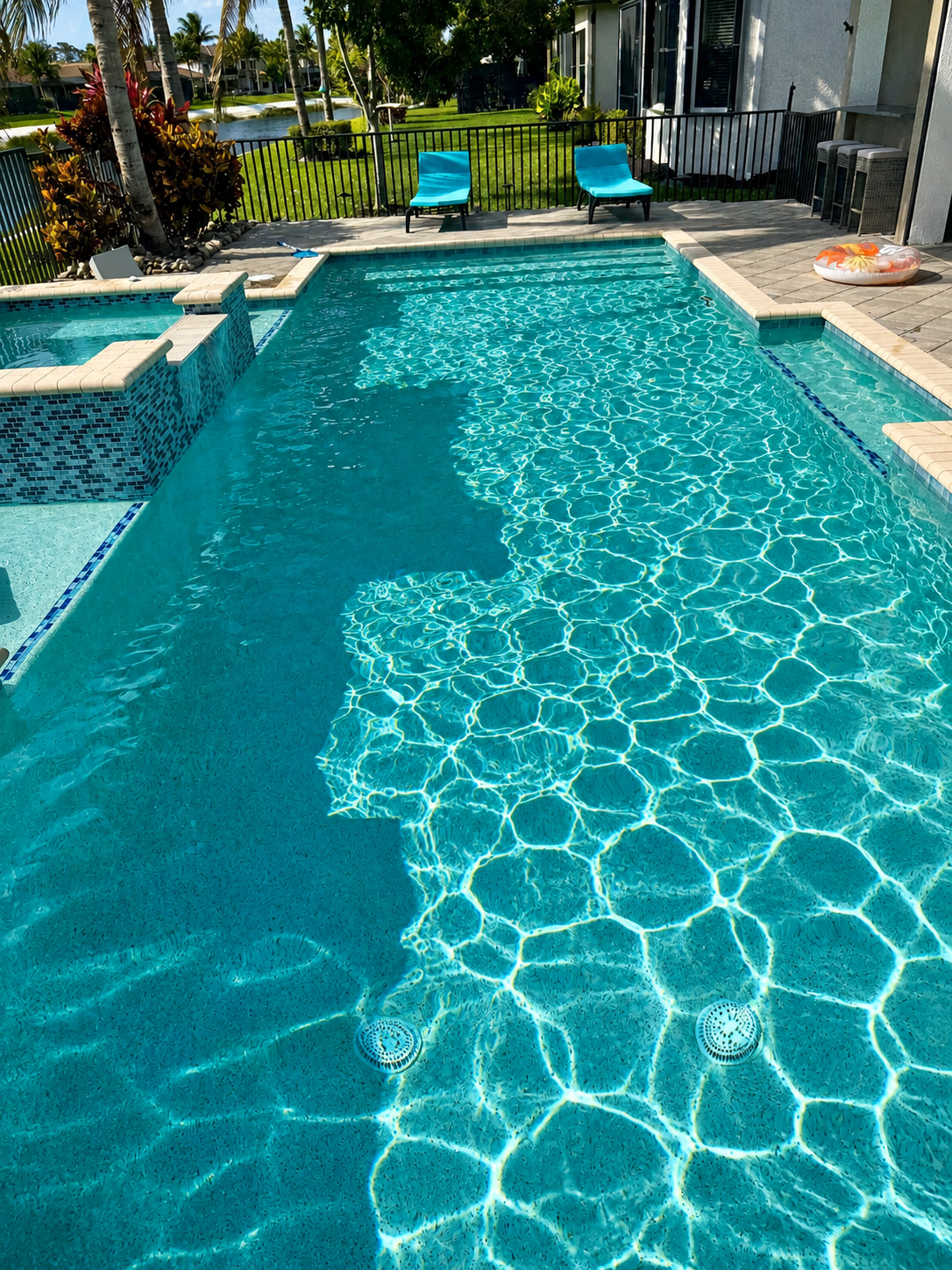 Pool cleaning service in Naples, FL backyard pool with clear blue water