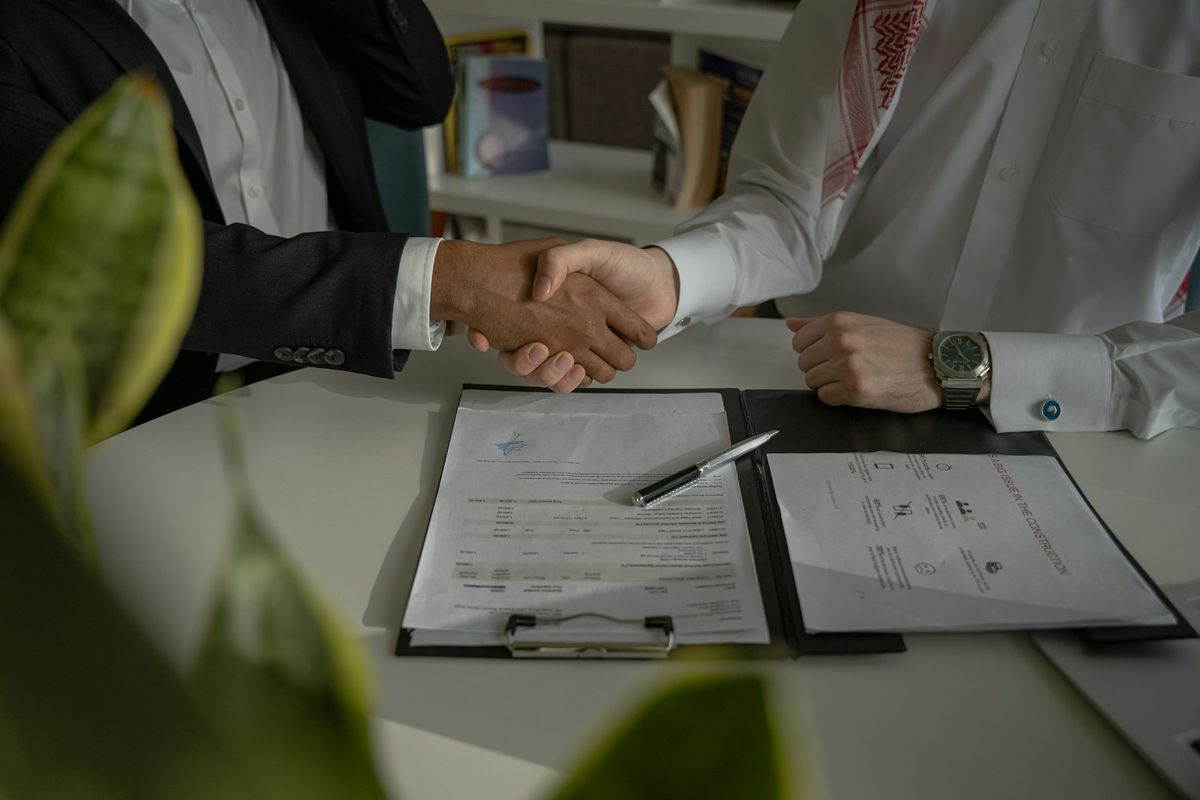 A handshake over signed papers A handshake over signed papers