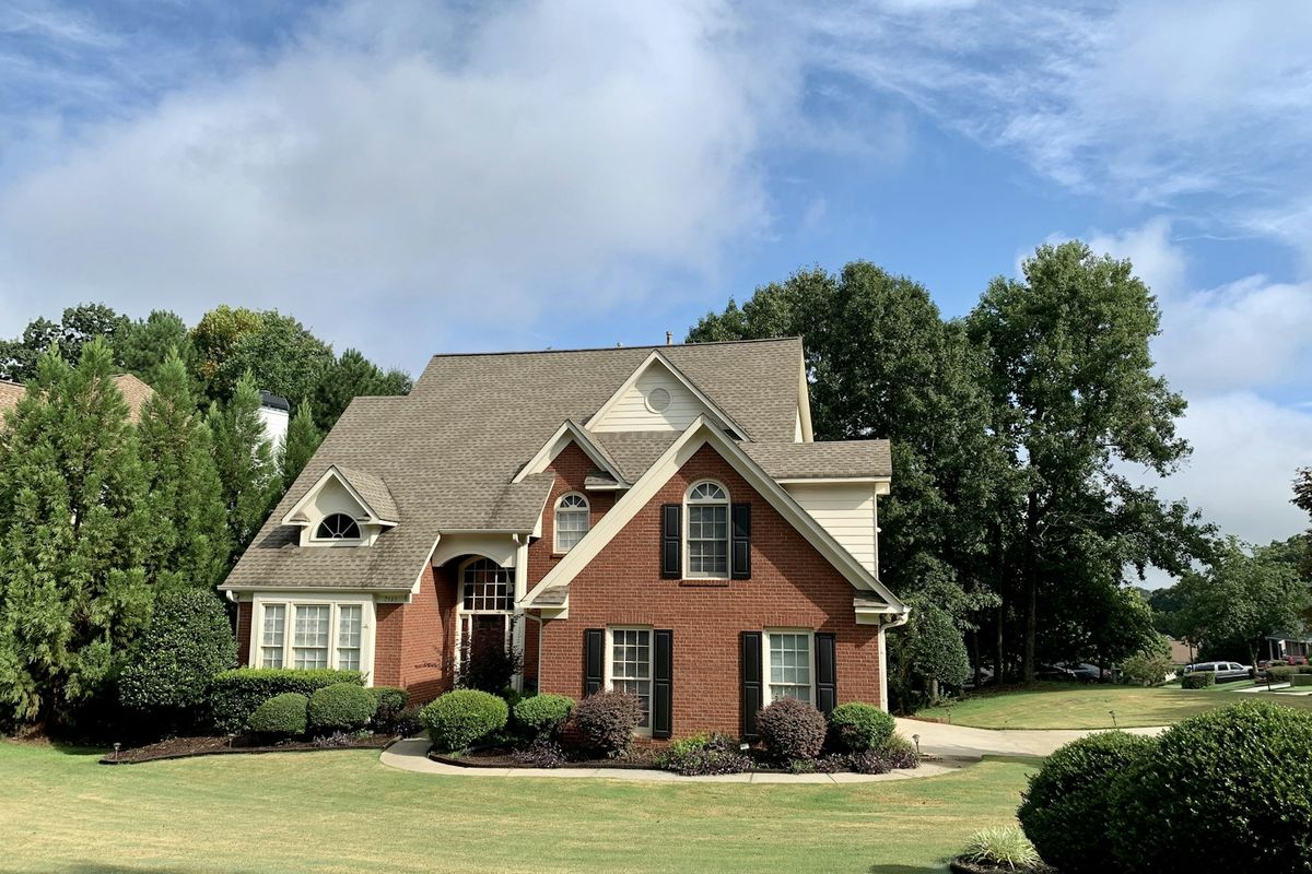 A brick home with a green lawn A brick home with a green lawn