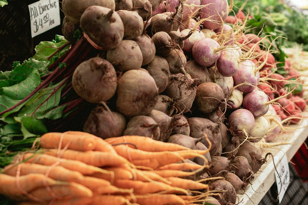Carrots and beets stacked at a farmers market