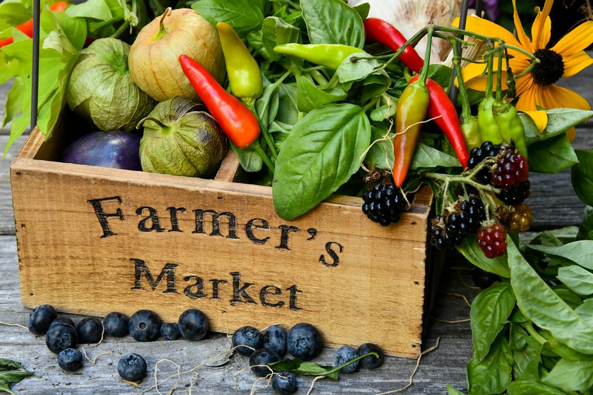 A wooden farmers market crate filled with fresh produce