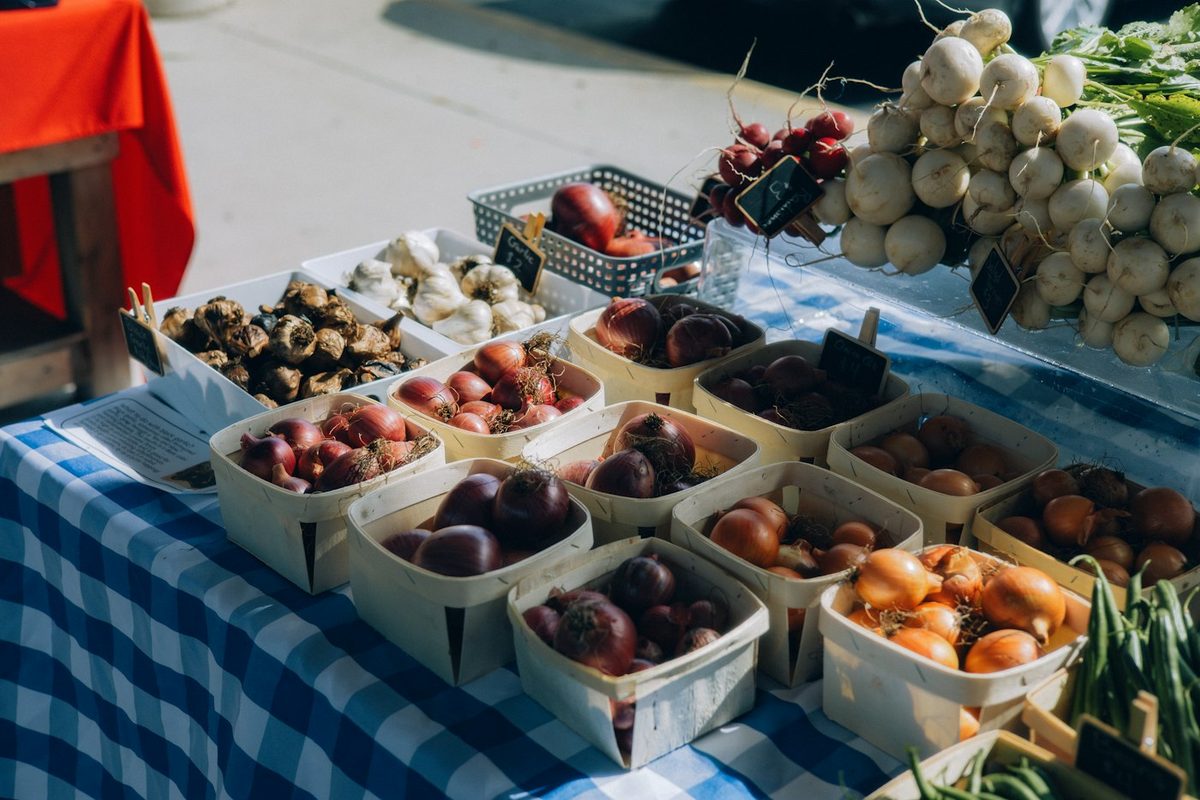 Produce in baskets on a checkered market table