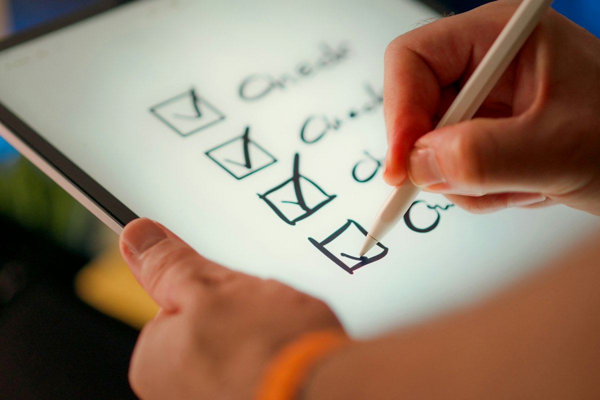 A hand checking off items on a checklist