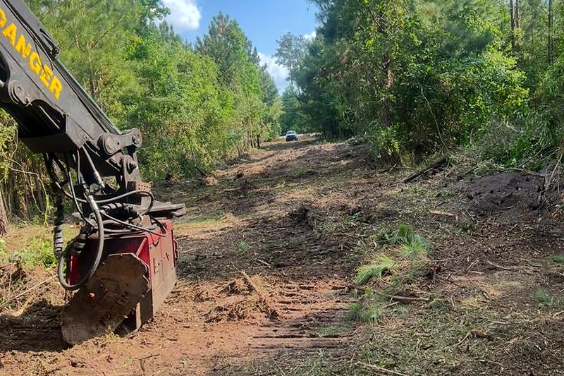 Machine opening up an overgrown property