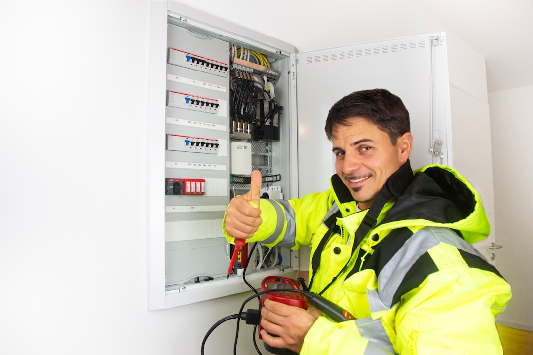 Electrician at electrical panel in hi-vis vest
