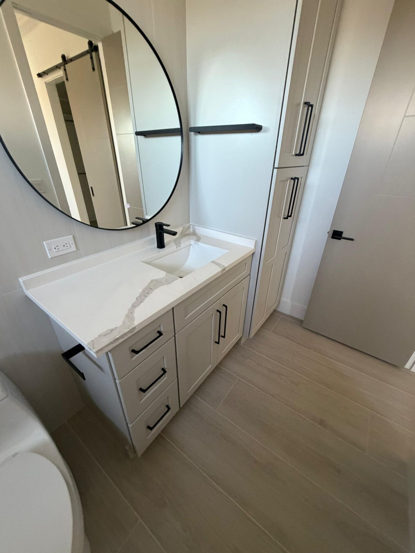 White quartz vanity with round mirror