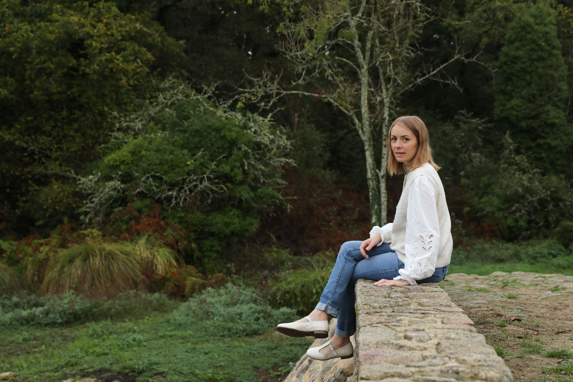 Gaëlle Mallet assise sur un muret dans la nature