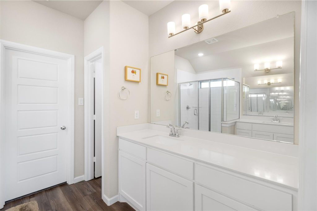 Bathroom with single vanity and walk-in shower