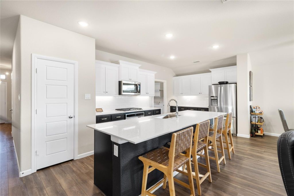 Kitchen with shaker cabinets, granite island, and stainless steel appliances