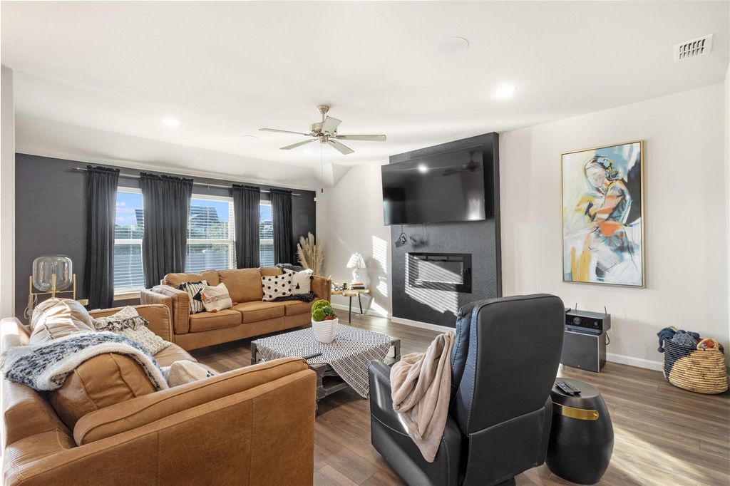 Living room with leather sofas, fireplace, and mounted TV
