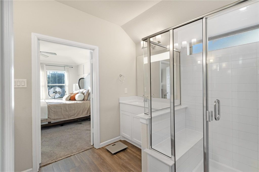 Primary bathroom with glass-enclosed shower and dual vanity