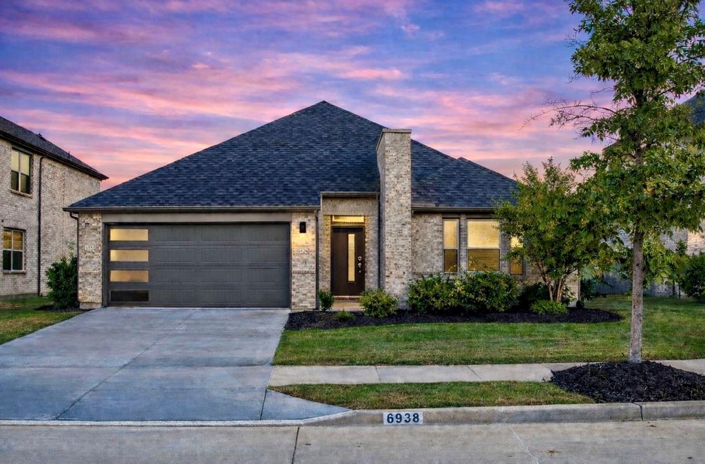 Front exterior of single-story brick home at sunset