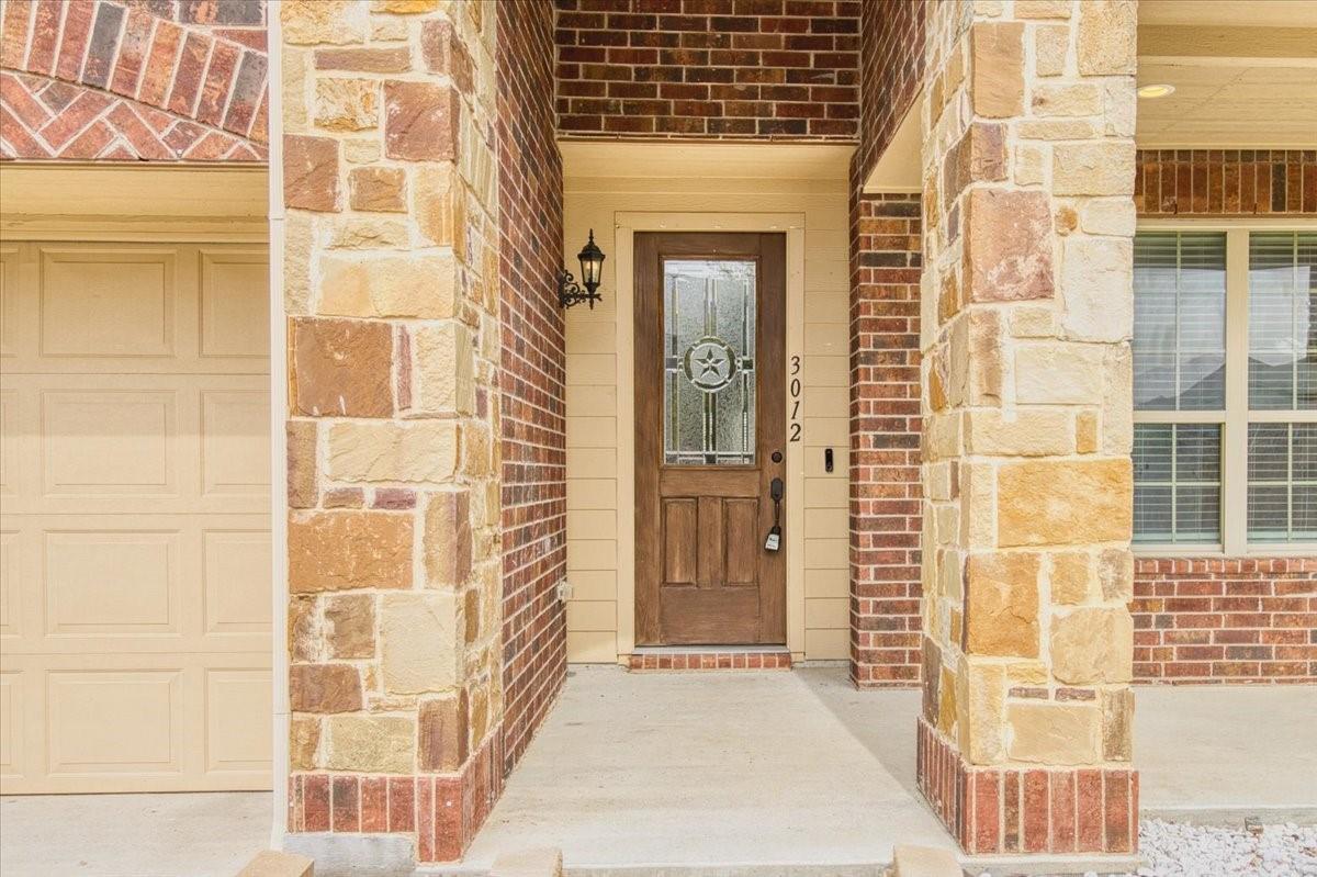 Covered entryway with brick facade and stone accents