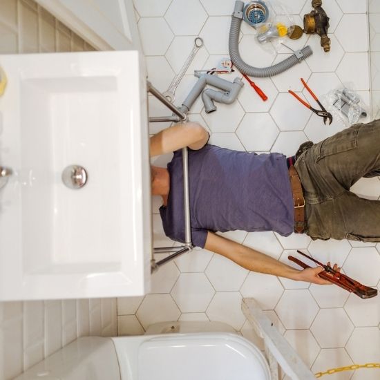 Drain plumber using hydro jetting to clear grease sludge and buildup