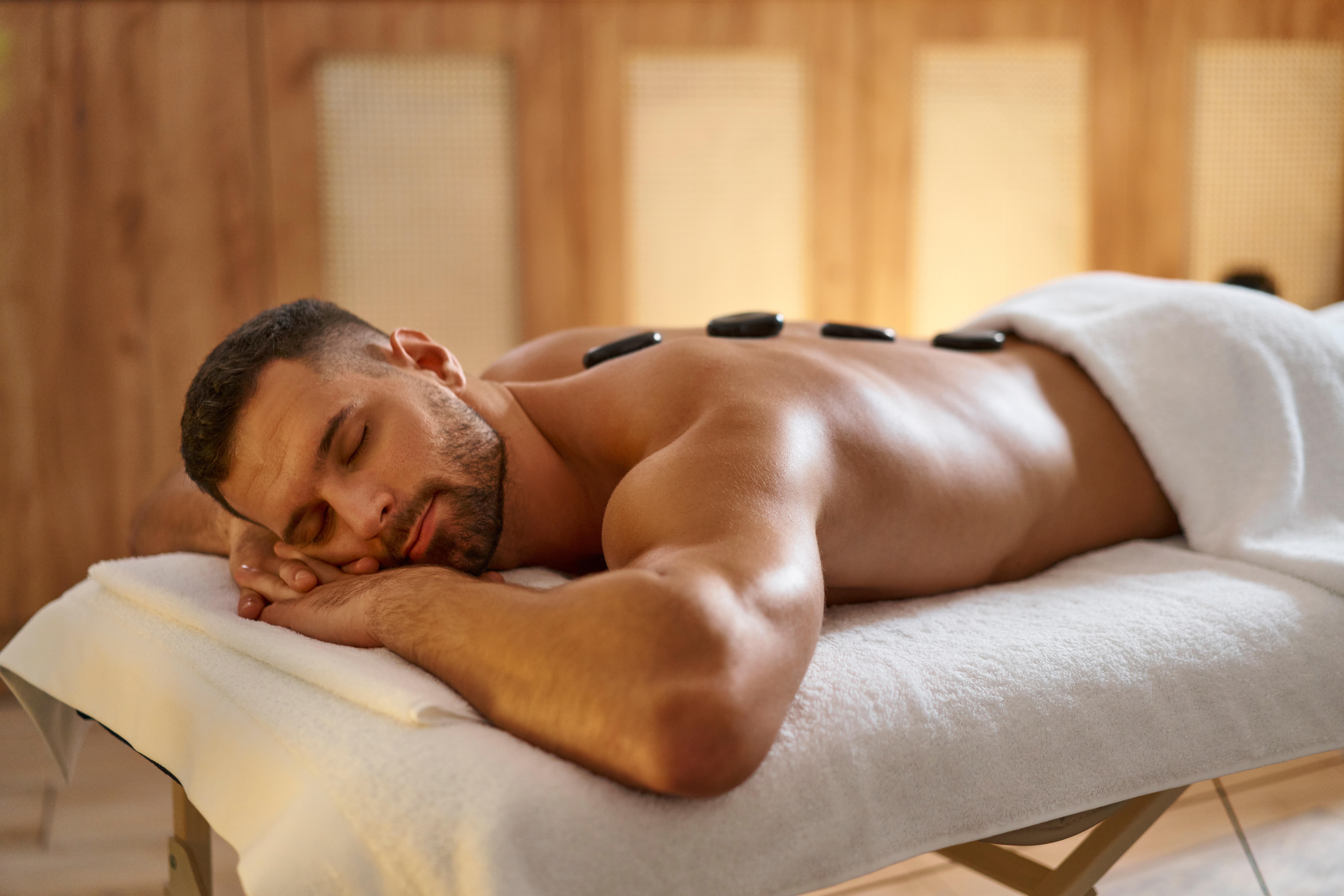 Licensed massage therapist performing deep tissue back massage in Regina clinic.