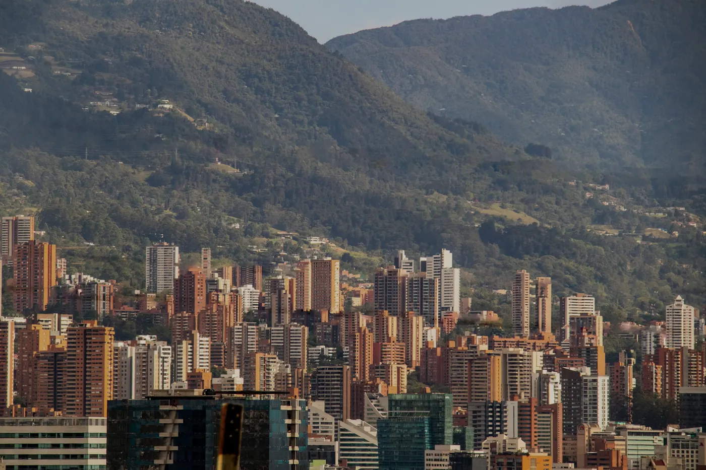 Torres del Poblado contra la montaña de Medellín al atardecer.
