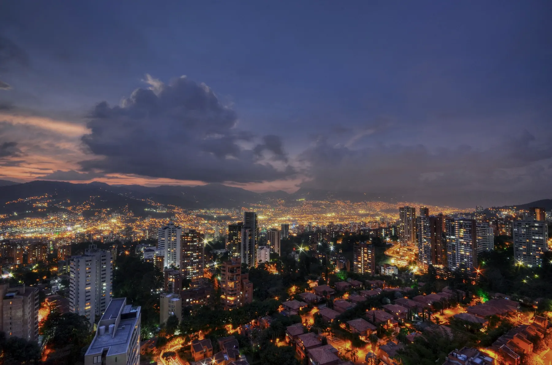 Medellín de noche, las luces de la ciudad entre las montañas.