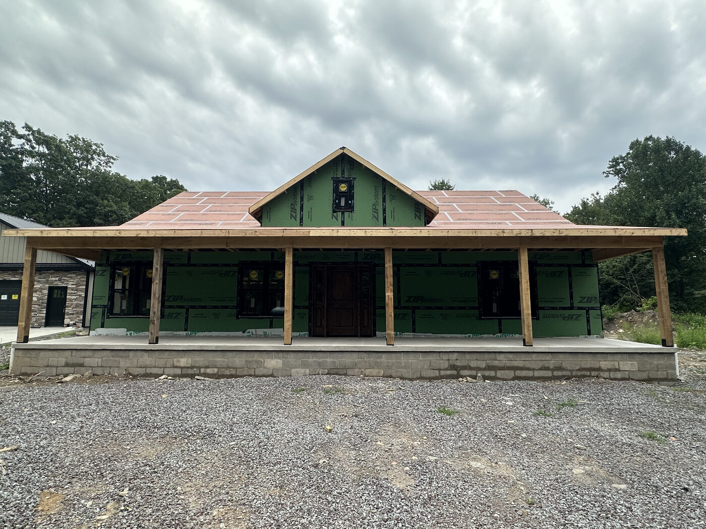 Home addition with covered porch, framed and wrapped