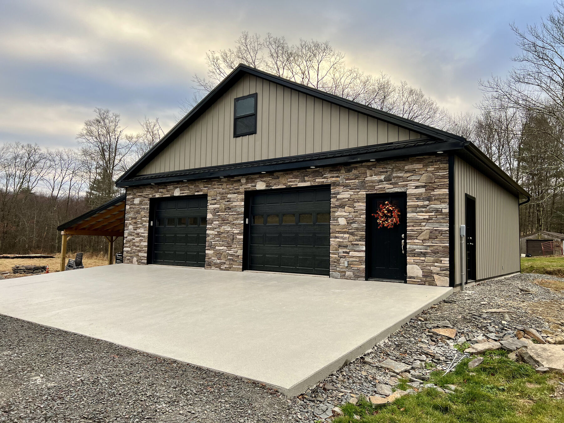 Finished stone and metal-roofed garage built by White Deer Builders on a difficult, rocky site